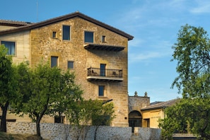 Un edificio in pietra con diverse finestre e un balcone.