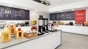 Une cuisine moderne équipée d’un coin café, d’un présentoir à fruits et d’une publicité pour des gaufres.