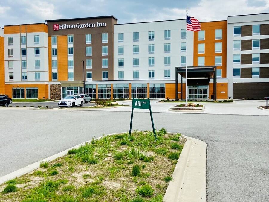 A Hilton Garden Inn hotel with a modern design, featuring multiple floors and a parking area.