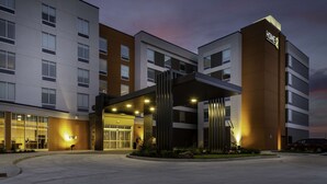 A multi-story hotel with a modern facade, large windows, and a well-lit entrance. - Home2 Suites by Hilton Fort Wayne North (Fort Wayne)