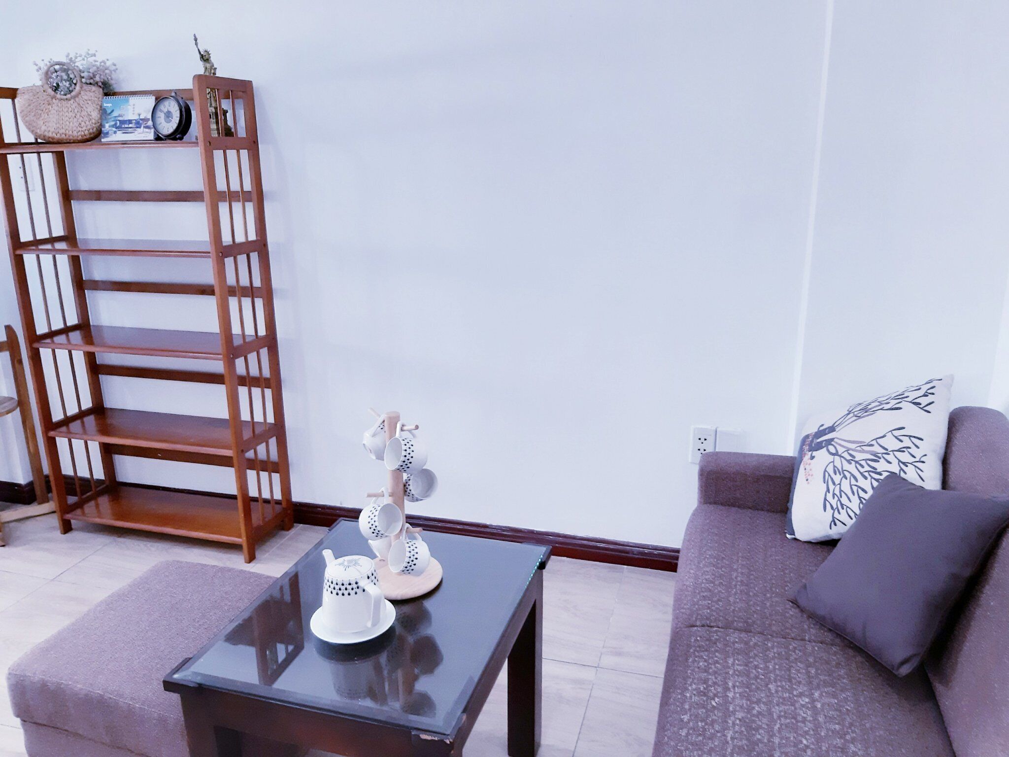 A living room with a sofa, a coffee table, a bookshelf, and a small decorative item on the table.
