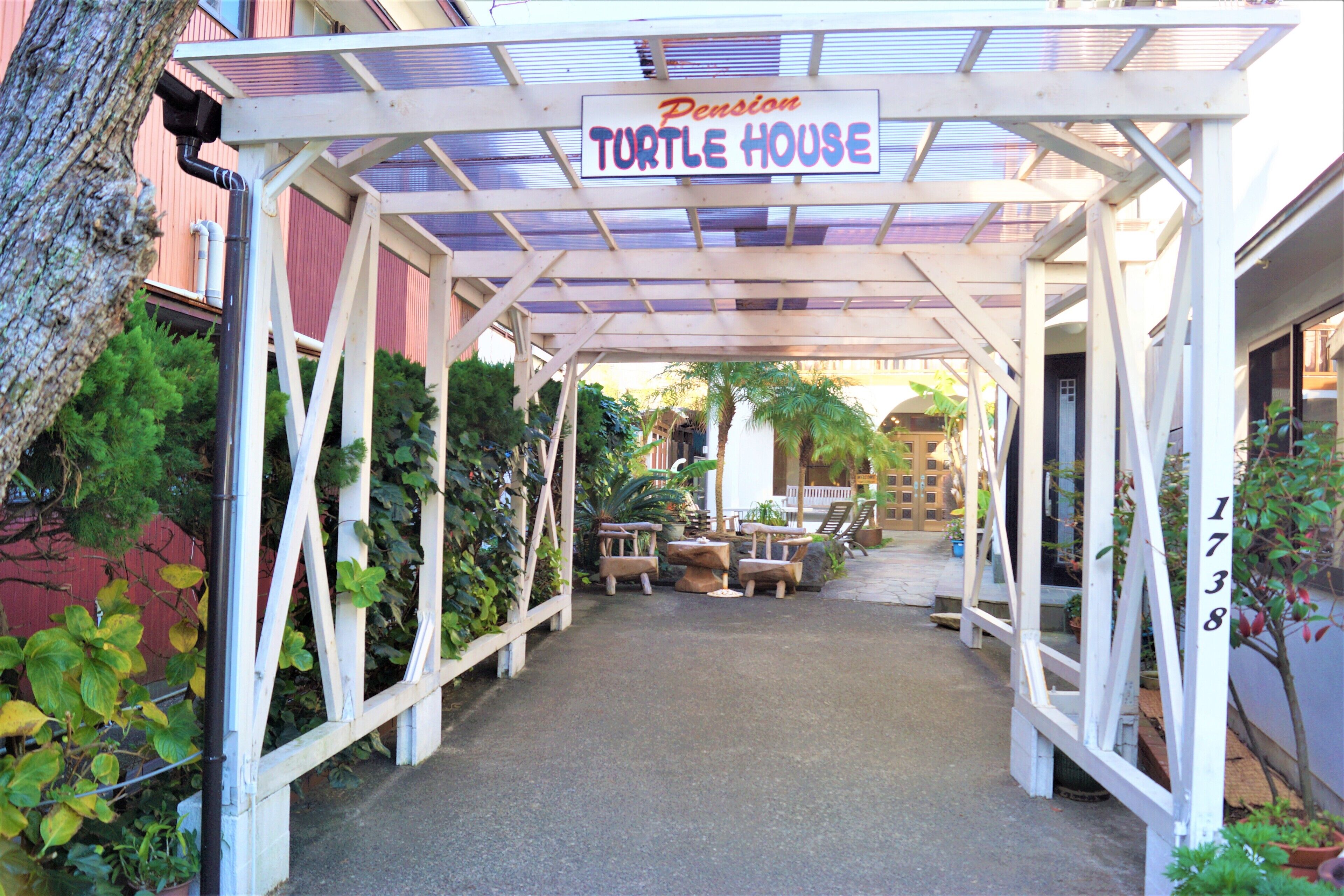 A covered walkway with a sign reading "Pension Turtle House."