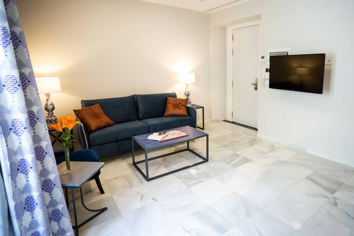 Uma sala de estar moderna com um sofá, mesa de centro e luminárias.