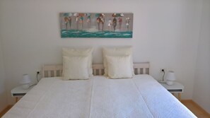 A bedroom with a large bed, two bedside tables with lamps, and a painting on the wall. - Private apartment Angelika NEW (Lorch)
