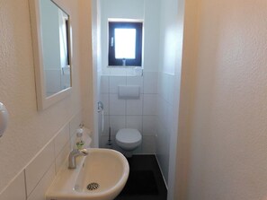 A narrow bathroom with a sink, toilet, and window. - Private apartment Angelika NEW (Lorch)