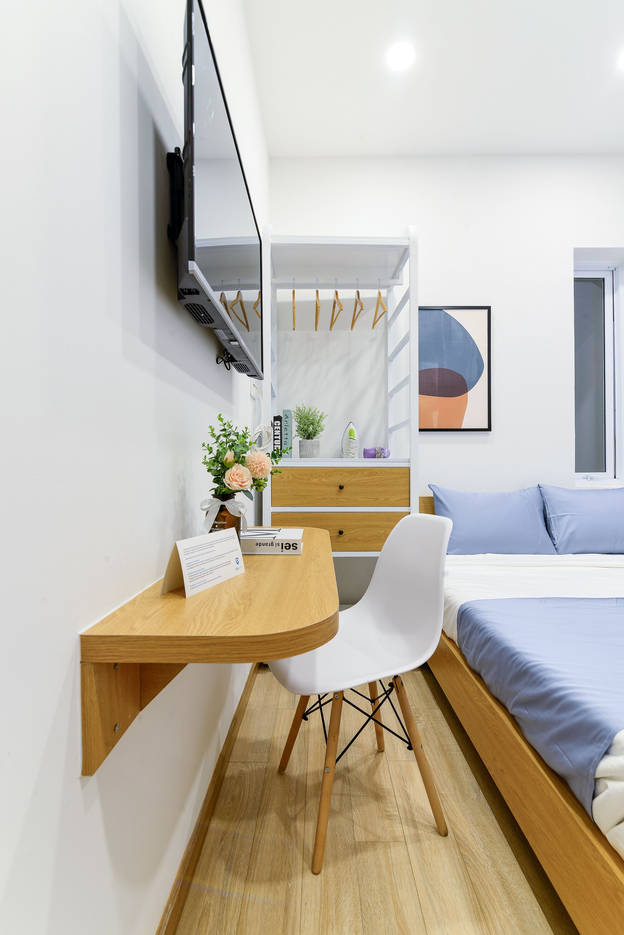 A modern bedroom with a bed, a desk, and a chair.