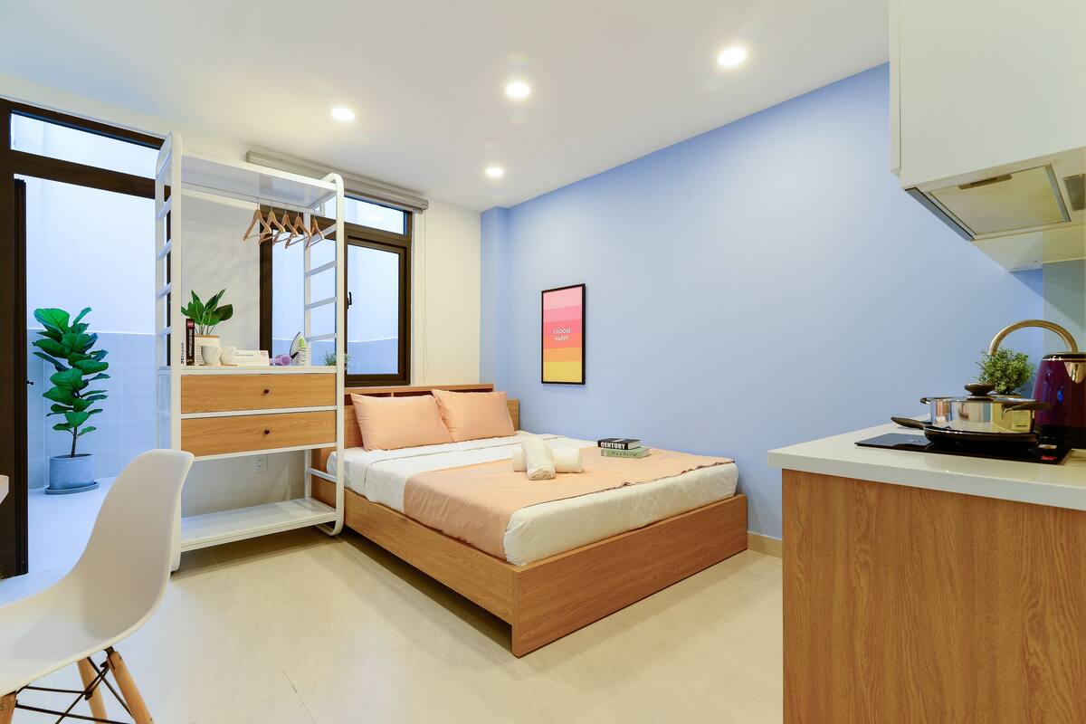 Un dormitorio moderno con cama, mesita de noche y espacio para escritorio.