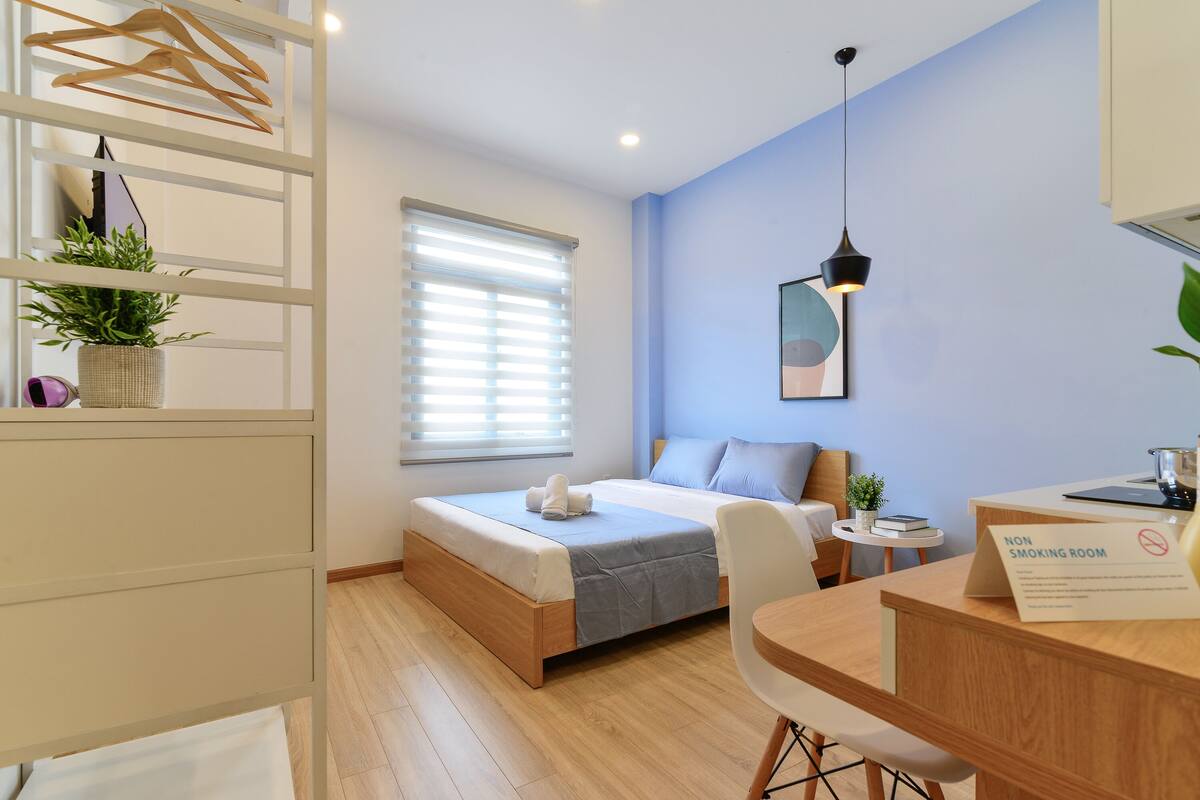 Un dormitorio moderno con cama, mesita de noche y zona de escritorio.