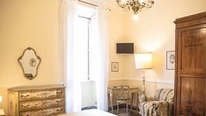 A bedroom with a bed, a dresser, a desk with a chair, a television, and a large wooden cabinet. - Residenza Maritti Classic Rooms (Rome)