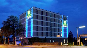 A multi-story building with illuminated signage for Holiday Inn Express.