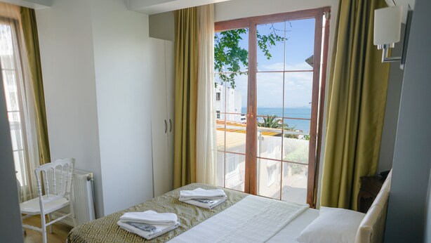 A hotel room with a bed, a chair, a window with a view of the sea, and a balcony. - My Way Cadde Butik Otel (Adalar)