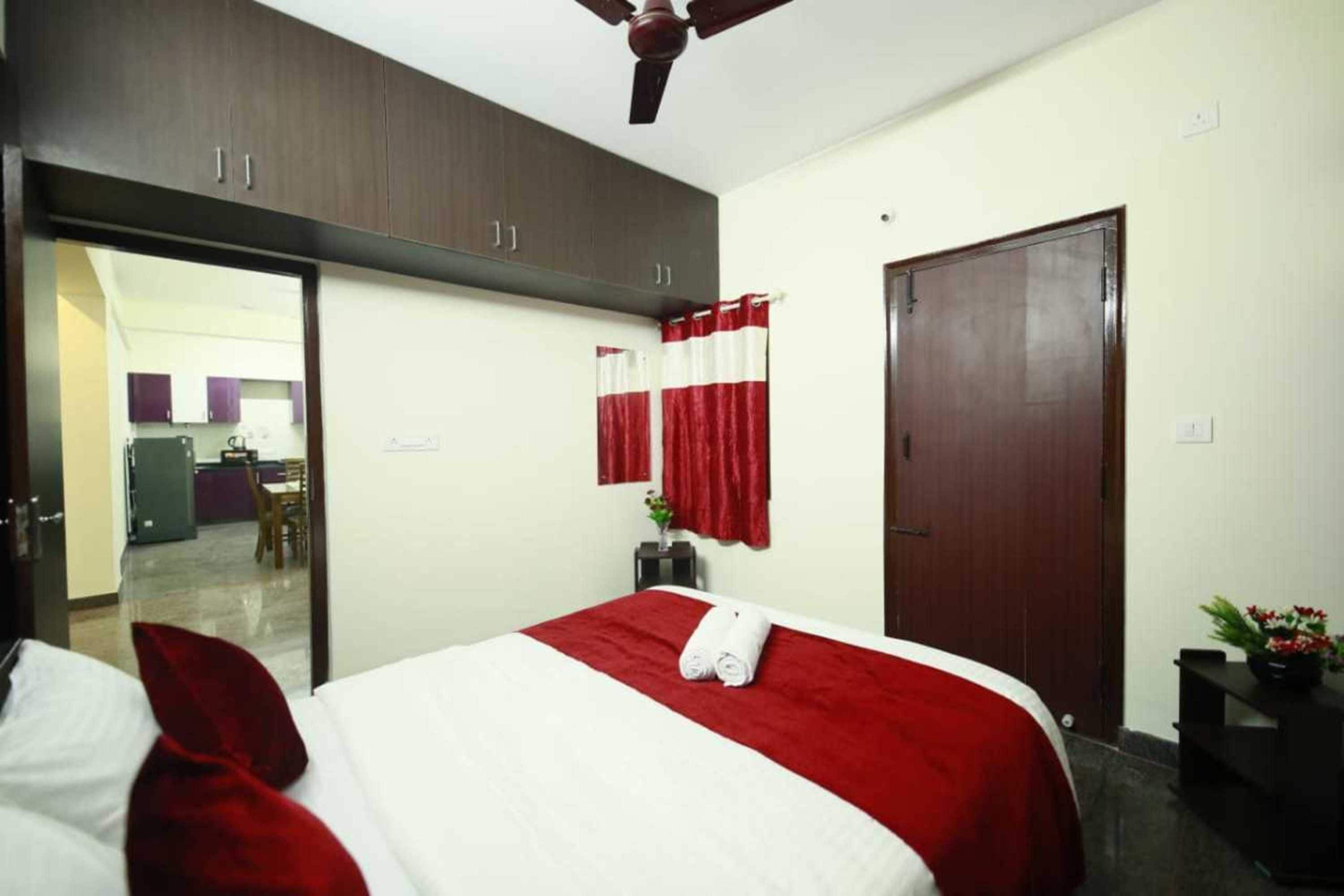 Une chambre d’hôtel avec un lit, une armoire, une porte et une vue sur le couloir.