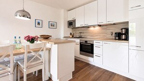 Una cocina moderna con armarios blancos, electrodomésticos de acero inoxidable y una isla de madera.