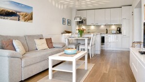 Una sala de estar moderna con un sofá, una mesa de centro y un comedor con sillas y una mesa.