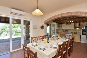 A dining area with a table set for four, wooden chairs, and a hanging light fixture.