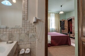A bathroom with a bathtub, a towel rack, and a telephone.