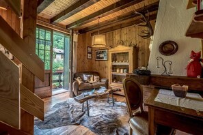 Step up to a comfortable living space with a sofa and dining table, offering scenic views from the large window.