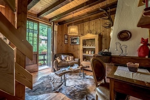 Step up to a comfortable living space with a sofa and dining table, offering scenic views from the large window.