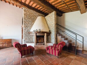 A stone fireplace with a chimney, two armchairs, a wooden staircase, and a wooden cabinet. - Villa / Independent home in Ponte A Moriano with 6 bedrooms sleeps 14 (Lucca)