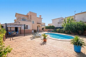 A residential property with a swimming pool, outdoor seating, and a covered patio area. - House with pool Son Moleto near the beach (Sa Rapita)