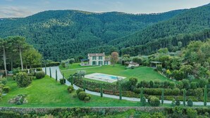 A house with a swimming pool surrounded by a well-maintained garden, set against a backdrop of forested hills. - Villa / Independent home in Lucca with 3 bedrooms sleeps 6 (Lucca)