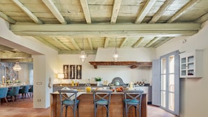 A kitchen with a bar area, wooden beams, hanging light fixtures, and a dining area with chairs. - Villa / Independent home in Lucca with 5 bedrooms sleeps 10 (Lucca)