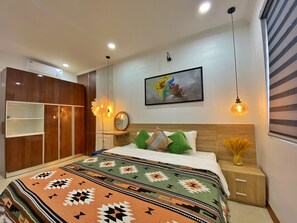 Un dormitorio con cama, armario, mesita de noche, espejo y un cuadro en la pared.