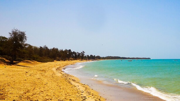 A beach with clear turquoise waters and a sandy shore lined with trees. - Villa watermelon Ngaparou 1 (Ngaparou)