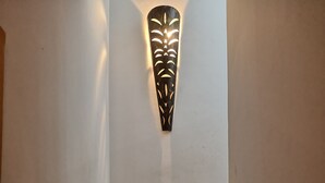 A staircase with a wall-mounted decorative light fixture. - Villa watermelon Ngaparou 1 (Ngaparou)