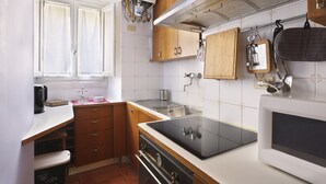 Una cucina compatta con fornello, lavello e finestra.