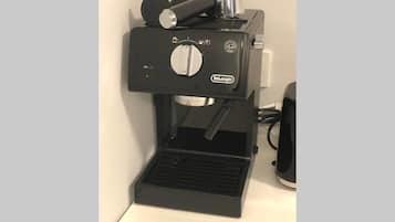 A De'Longhi espresso machine with a drip tray, control panel, and steam wand.