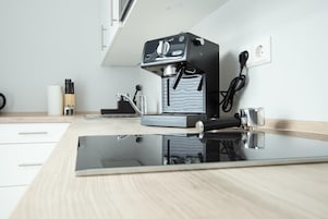 Uma cozinha moderna com máquina de café expresso embutida, moedor de café e bancada elegante.