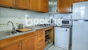 A kitchen with wooden cabinets, a stainless steel sink, a Bosch dishwasher, and a microwave.