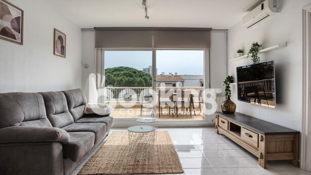 A modern living room with a grey sofa, a coffee table, and a TV on a wooden stand.
