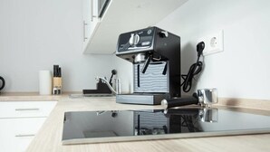Uma cozinha moderna com máquina de café expresso embutida, moedor de café e bancada elegante.