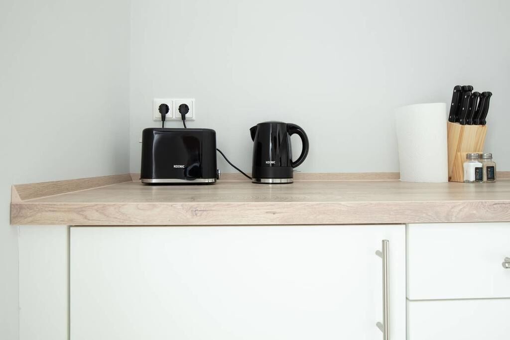 Un plan de travail de cuisine avec un grille-pain, une machine à café et un bloc à couteaux.