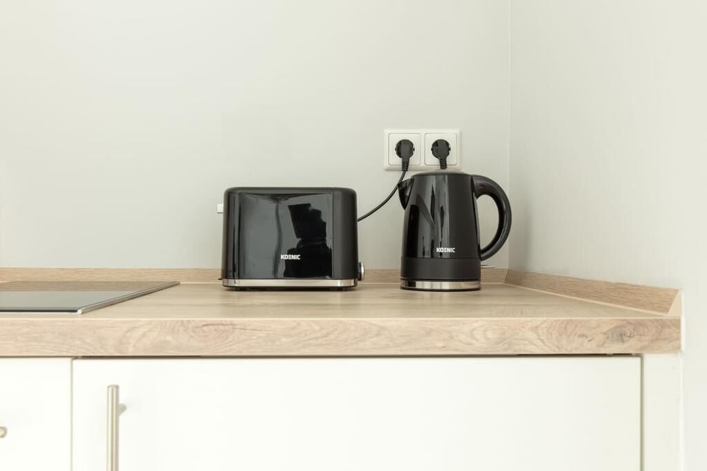 Une cuisine avec un grille-pain et une machine à café posés sur un plan de travail.