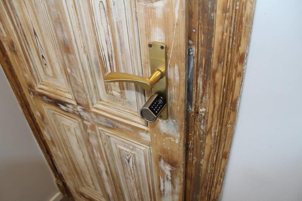 A wooden door with a brass handle and a keyhole.
