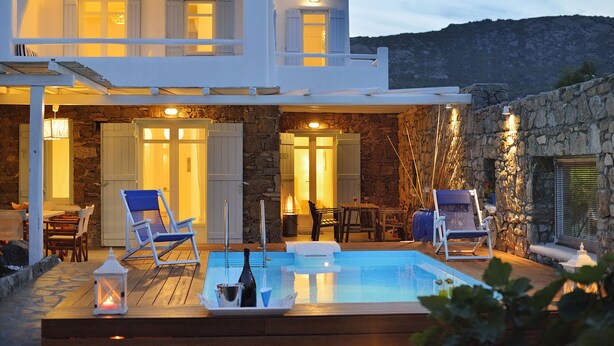 A two-story building with a pool area, outdoor seating, and stone walls. - Villa Akoya III by The Pearls Collection (Mykonos)
