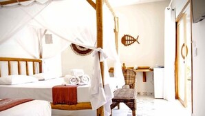 A room with a four-poster bed, a chair, a small table, and a fish wall decoration. - Pousada Paraíso dos Ventos (Cruz)