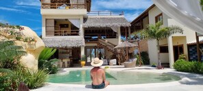 Una piscina al aire libre, sillones reclinables de piscina