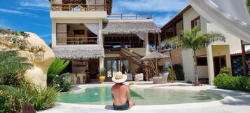 Una piscina al aire libre, sillones reclinables de piscina