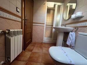 A bathroom with a toilet, sink, and shower. - Casa Alberto (Castro Caldelas)