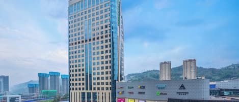 A high-rise hotel with a prominent sign, surrounded by other buildings and a busy street.