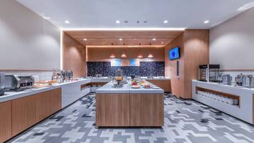 A modern kitchen with a central island, wooden cabinets, and a patterned backsplash.