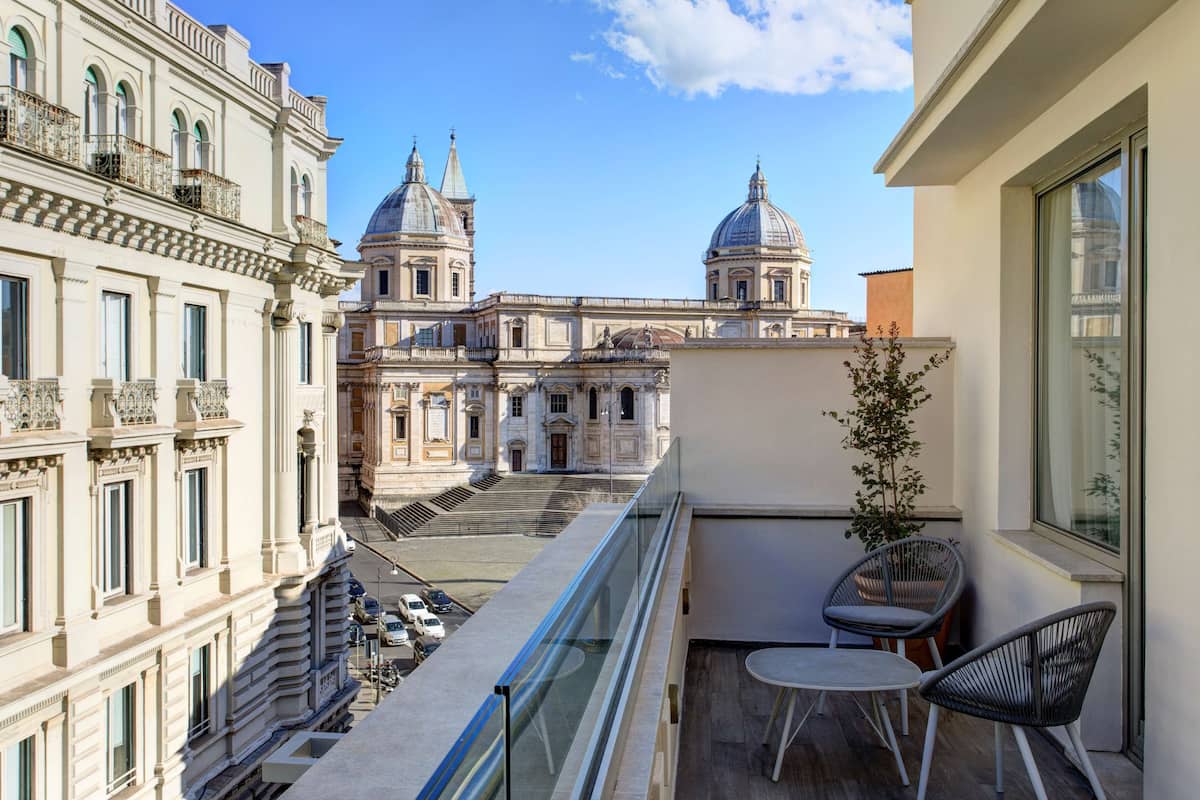 A balcony with a view of historic buildings, including two domed structures.