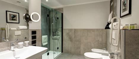 Un baño moderno con ducha de vidrio, lavamanos doble y un inodoro.