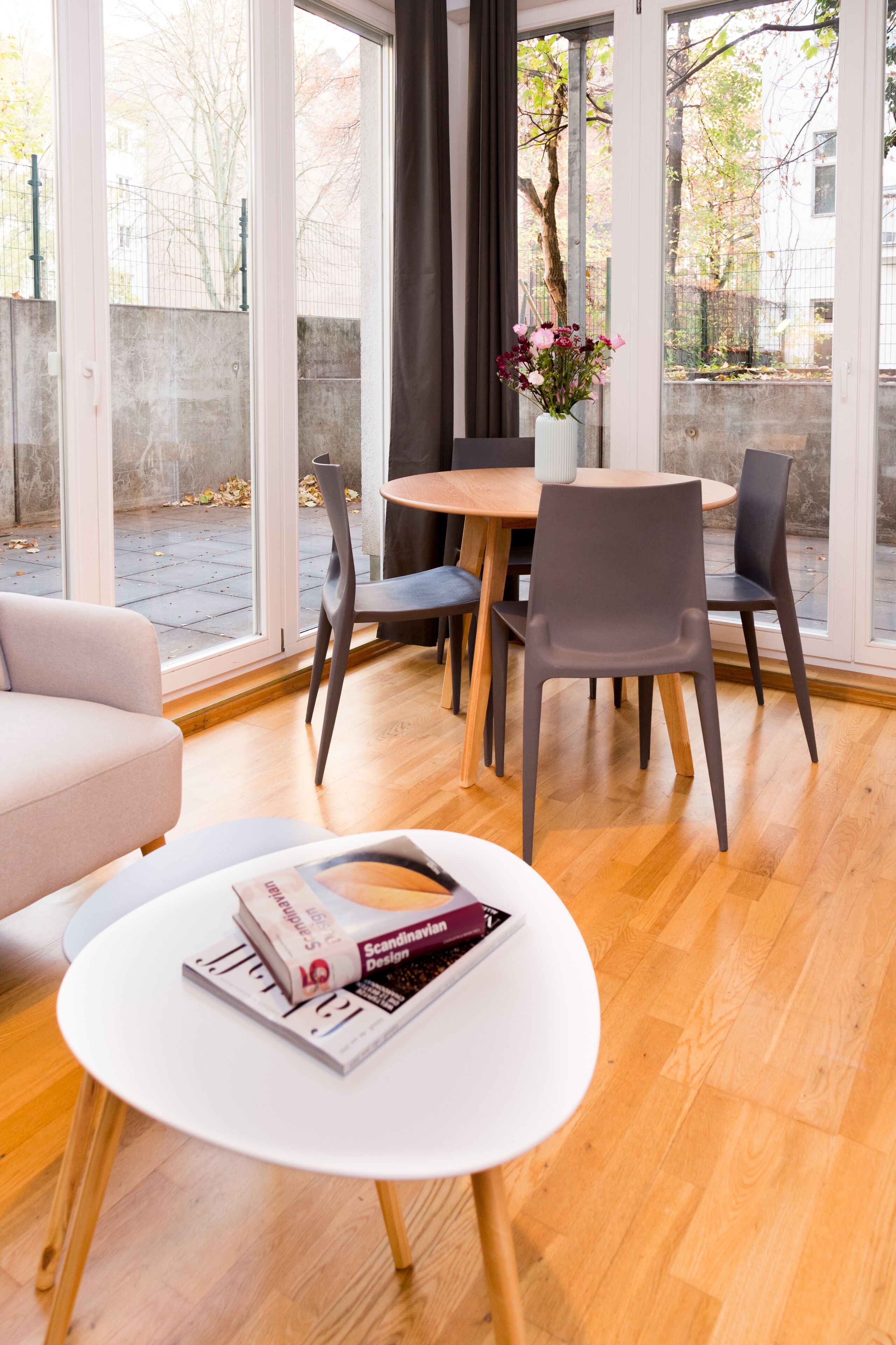 Una habitación moderna con comedor, ventanas amplias y vistas al exterior.