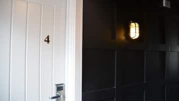 A door with the number 4, a modern door handle, and a wall-mounted light fixture.