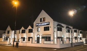 Una hilera de edificios de apartamentos blancos con un letrero que dice 'Sky City Apartments'.